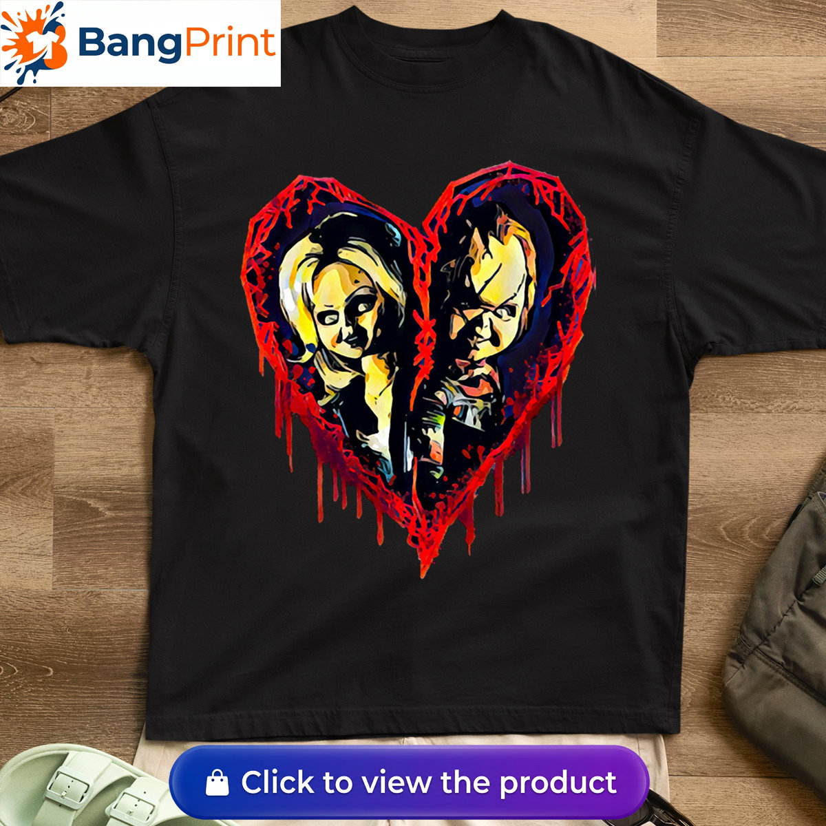 Black short-sleeve t-shirt displaying a graphic of a broken, dripping red bloody heart containing the stylized faces of horror movie characters Chucky and Tiffany.